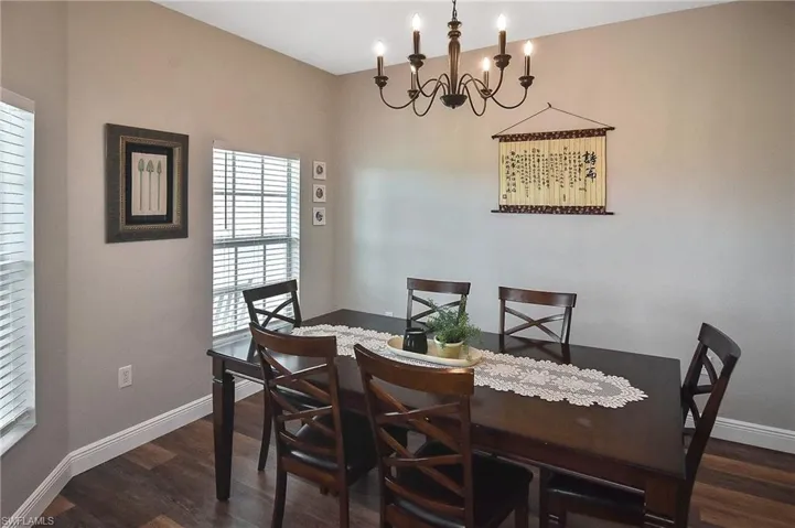 Dining space featuring a chandelier and dark wood-type flooring