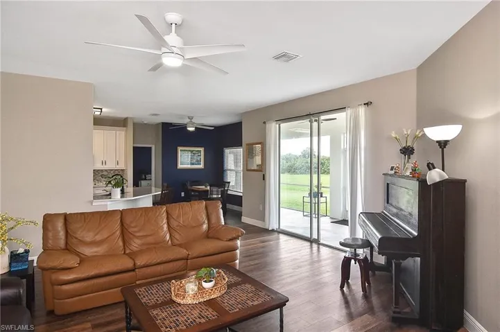 Living room featuring dark wood-style floors and a ceiling fan