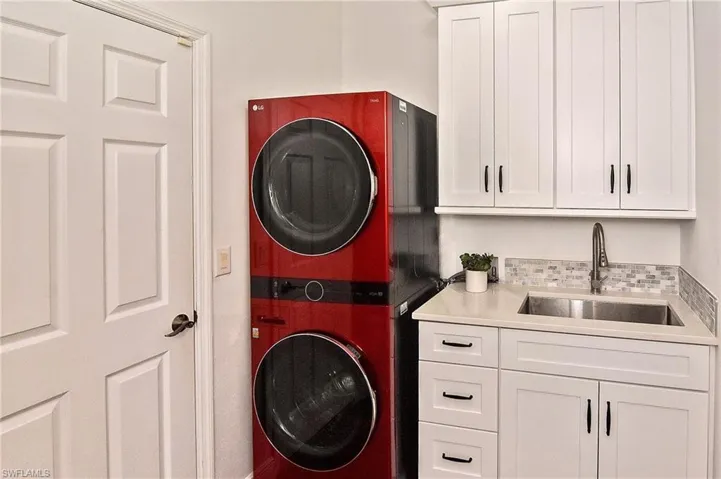 Laundry area with stacked washer / dryer and cabinet space