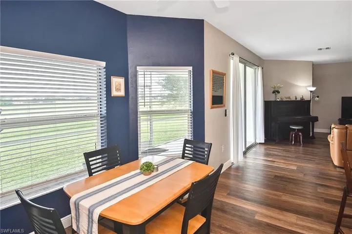 Dining room with dark wood finished floors and a ceiling fan