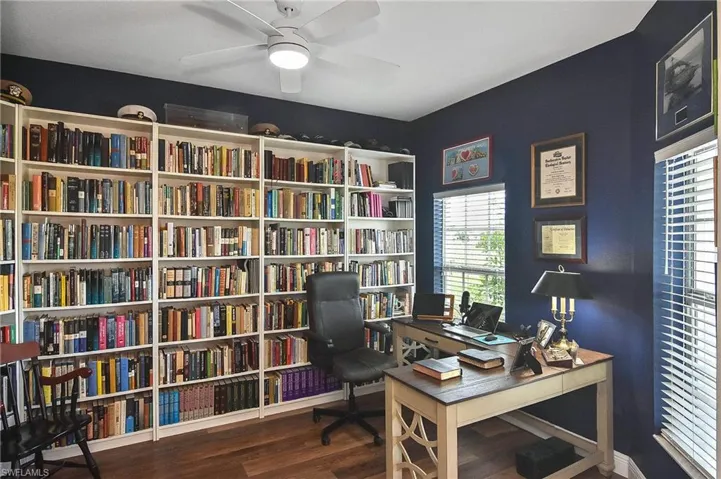 Office area with dark wood-style flooring and a ceiling fan