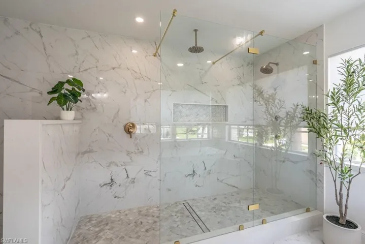 Bathroom with a marble finish shower, plenty of natural light, marble finish flooring, and recessed lighting