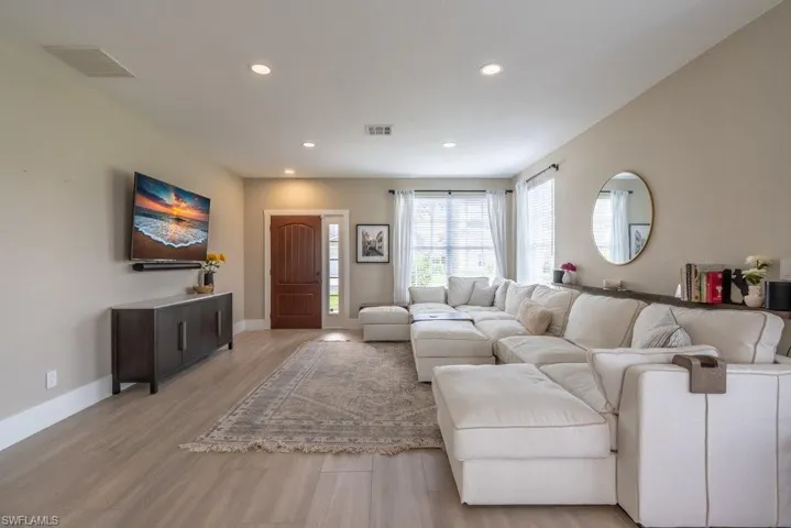 Living area featuring light wood-style floors and recessed lighting