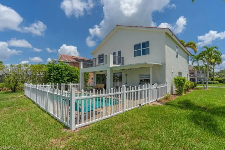 Rear view of house with a balcony, a patio, and stucco siding