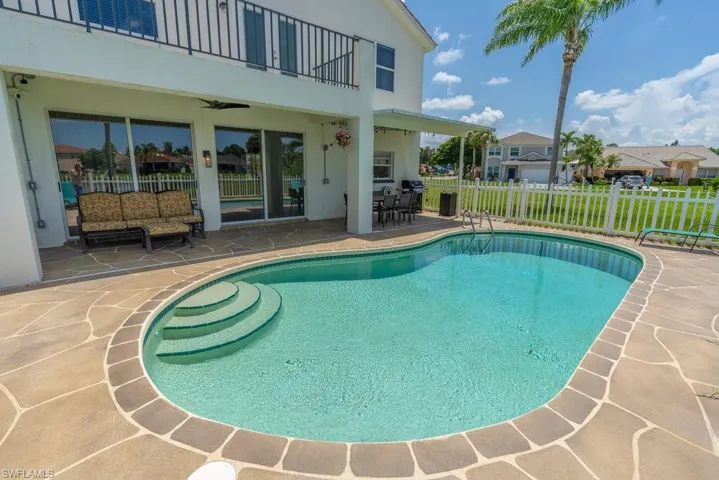 View of pool with a patio area, ceiling fan, and outdoor dining space