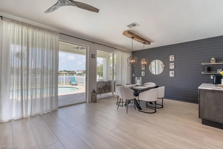 Dining room with ceiling fan, light wood-type flooring, and a chandelier