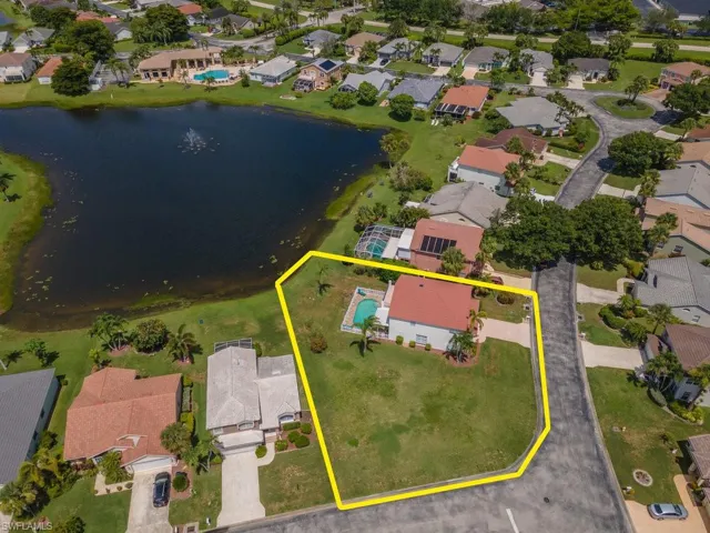 Aerial view of residential area featuring property parcel outlined and a nearby body of water