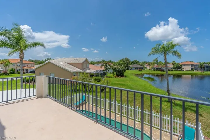 Balcony with a residential view, a water view, and view of pool area