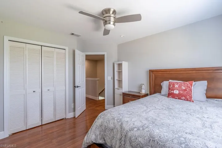 Bedroom with wood finished floors, a closet, and a ceiling fan