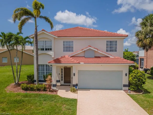 Mediterranean / spanish-style house with a tiled roof, a front yard, and driveway