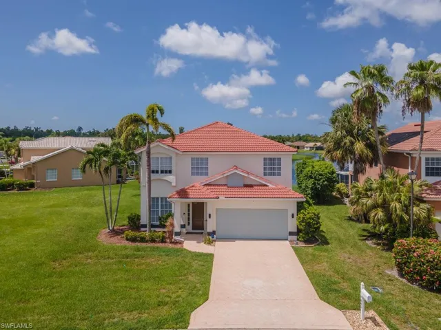 Mediterranean / spanish house featuring stucco siding, a tile roof, driveway, and a front yard
