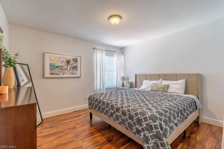 Bedroom with wood finished floors and baseboards