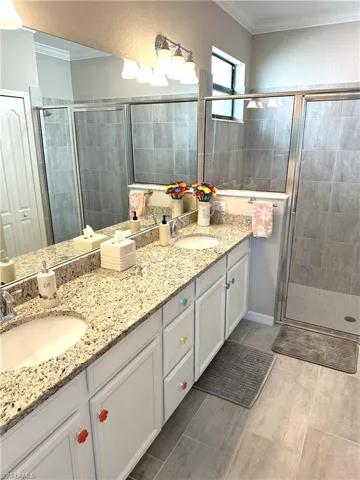 Bathroom with vanity, crown molding, and walk in shower