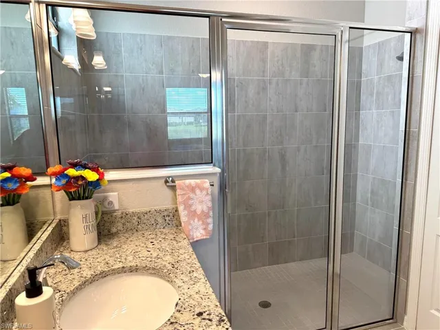 Bathroom with vanity and a shower with shower door