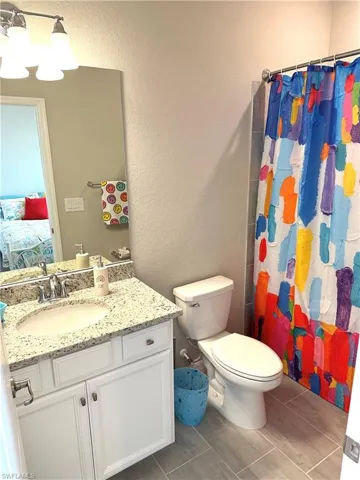 Bathroom with a shower with curtain, vanity, and toilet