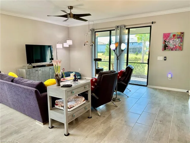 Living room featuring crown molding and ceiling fan