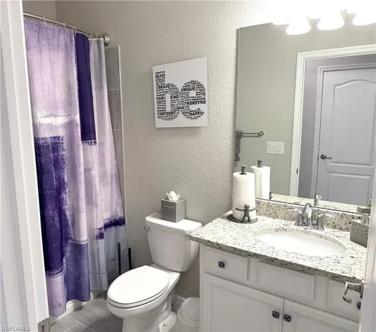 Bathroom featuring vanity, toilet, and walk in shower
