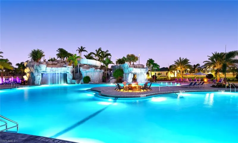 Pool at dusk with a patio and pool water feature