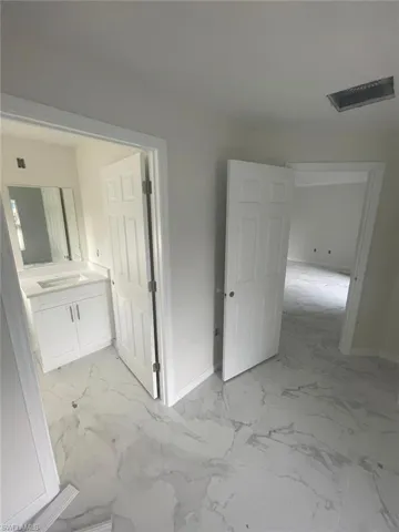 Hallway featuring light tile floors