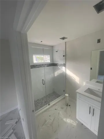 Bathroom featuring vanity and a shower with door
