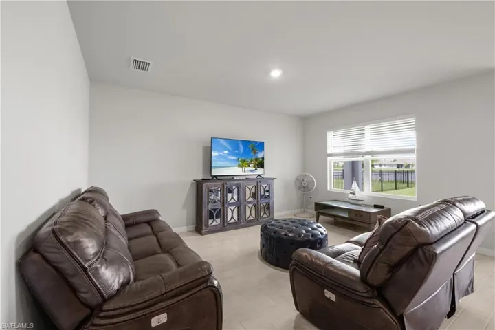 Spacious room featuring light-toned tile flooring, recessed lighting, and a large window with white blinds