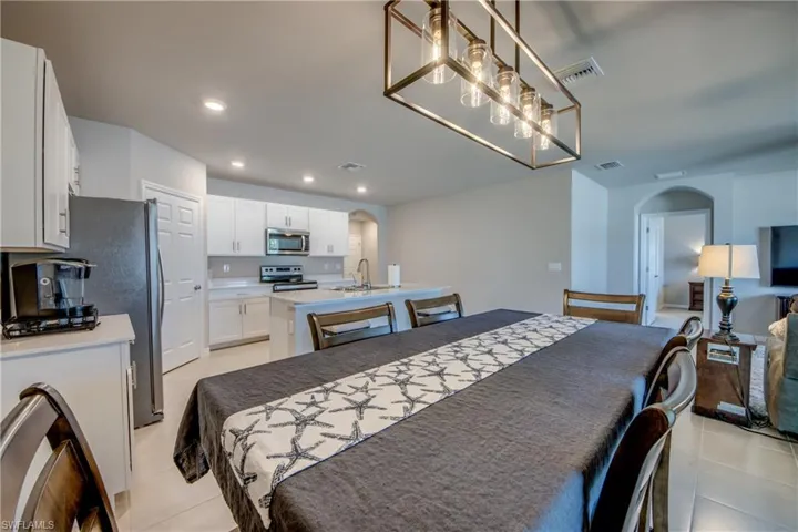 Dining room with modern chandelier and view of backyard