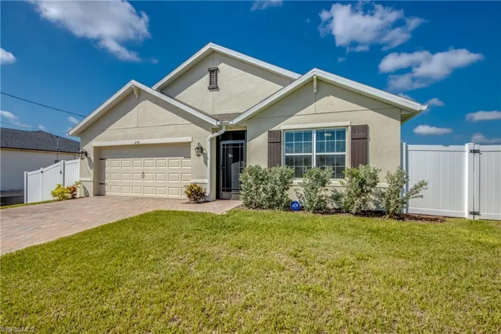 View of front of home with a 2 car garage and paver driveway