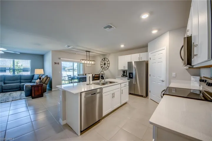 Kitchen featuring a large island, stainless steel appliances, quartz counters and designer cabinets