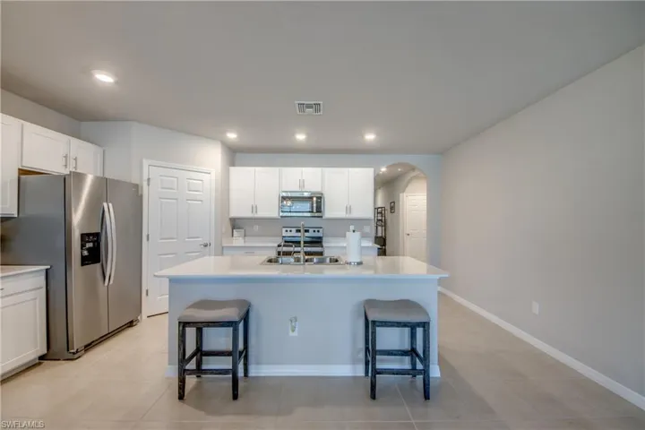 Kitchen featuring a large island, stainless steel appliances, quartz counters and designer cabinets
