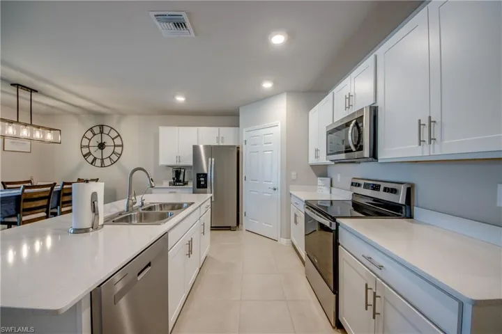 Kitchen featuring a large island, stainless steel appliances, quartz counters and designer cabinets
