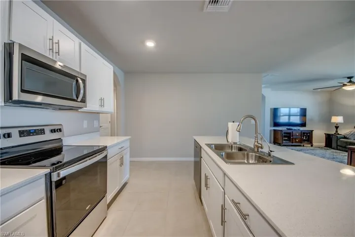 Kitchen featuring a large island, stainless steel appliances, quartz counters and designer cabinets