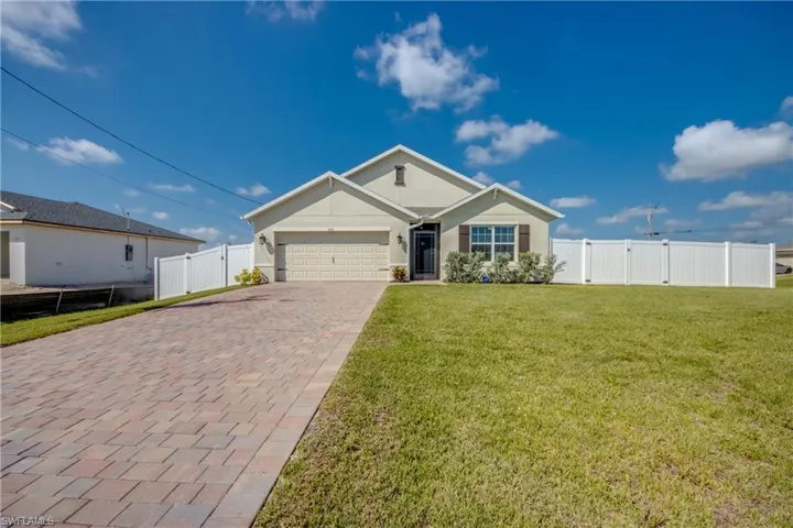 View of front of home with a 2 car garage and paver driveway