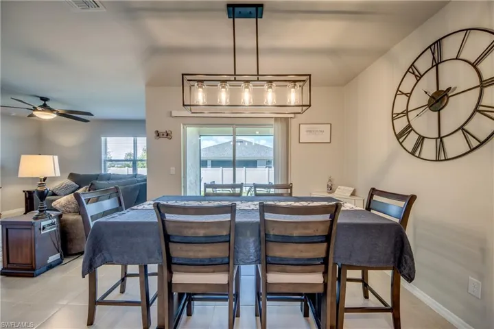 Dining room with modern chandelier and view of backyard