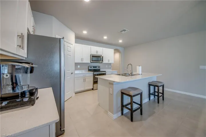 Kitchen featuring a large island, stainless steel appliances, quartz counters and designer cabinets