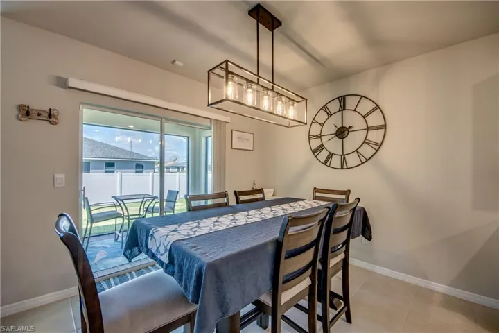 Dining room with modern chandelier and view of backyard