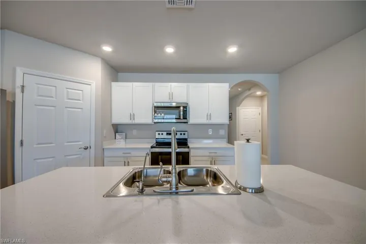 Kitchen featuring a large island, stainless steel appliances, quartz counters and designer cabinets