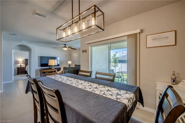 Dining Room with modern chandelier and view of backyard