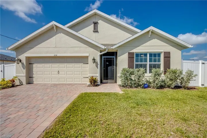 View of front of home with a 2 car garage and paver driveway