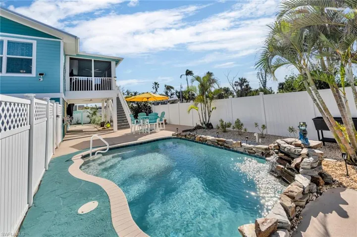 View of swimming pool featuring a patio, pool water feature, and a sunroom