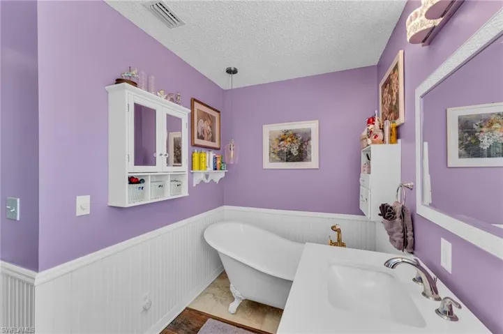 Bathroom featuring sink, a bathtub, a textured ceiling, and hardwood / wood-style flooring