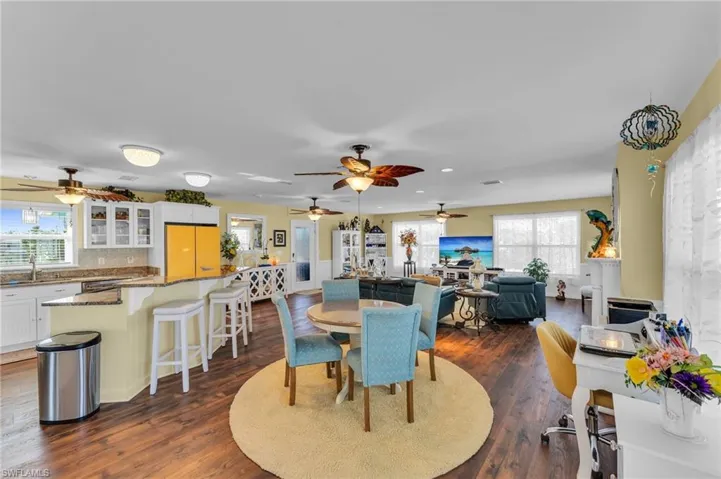 Dining area with ceiling fan, dark wood-type flooring, and sink