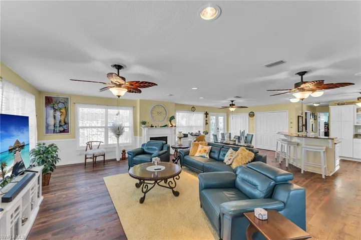 Living room with ceiling fan and dark hardwood / wood-style flooring