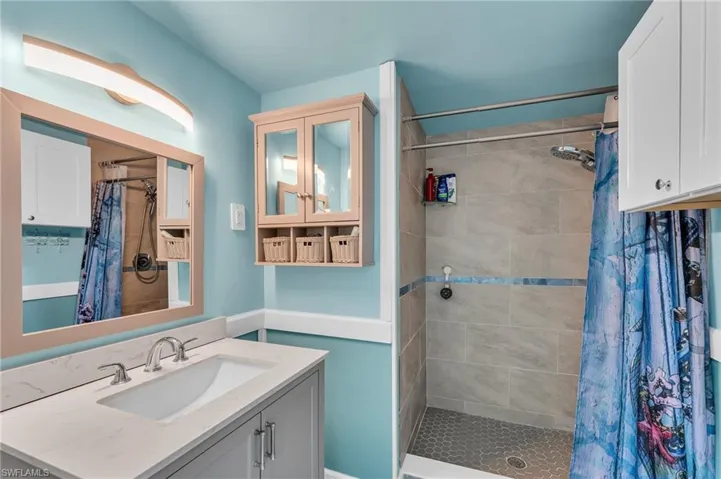 Bathroom featuring curtained shower and vanity