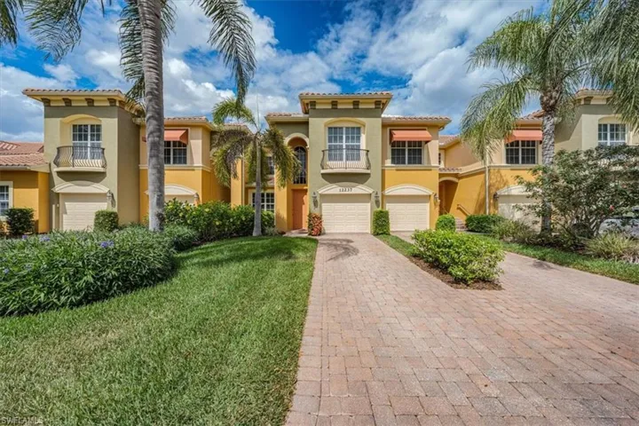 Mediterranean / spanish house with decorative driveway, stucco siding, a garage, a tiled roof, and a front lawn