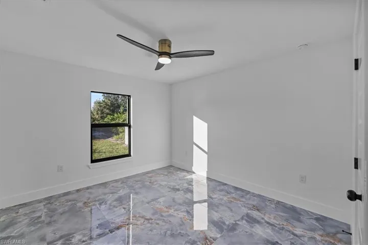 Empty room with light marble finish flooring and ceiling fan