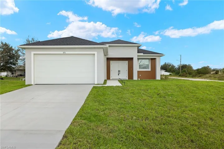 View of front of house featuring a front yard and a garage