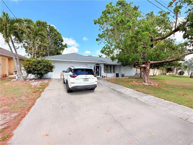 Ranch-style house with an attached garage, a front lawn, and concrete driveway