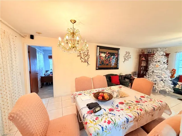 Dining space featuring a chandelier, light tile patterned flooring, and plenty of natural light