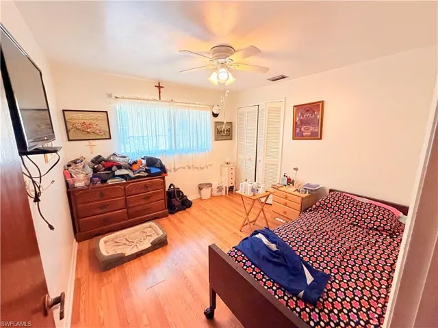 Bedroom with wood finished floors, a closet, and ceiling fan