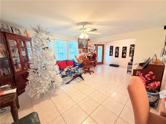 Living room with ceiling fan and light tile patterned floors